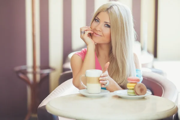 一个年轻的金发女郎，坐在一个咖啡馆的肖像 — Stock fotografie