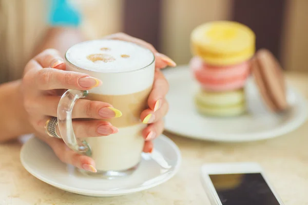 Filiżankę gorącej kawy latte z rzeźby kolorowe ciasteczka — Zdjęcie stockowe