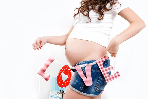 Portrait of pregnant woman with word love. — Stock Photo, Image