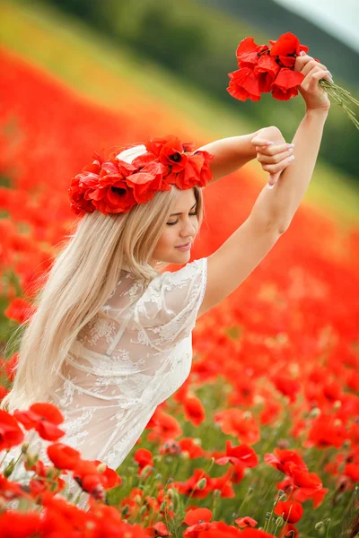 Beautiful young blonde woman in red bright poppy field. — Stock Photo, Image