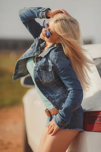 Retrato de una joven rubia guapa con coche de lujo — Foto de Stock