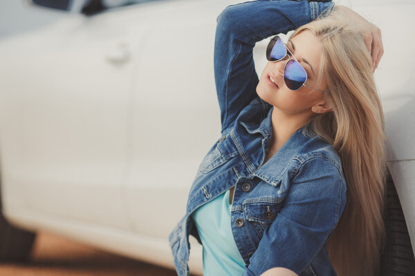 Portrait of a young pretty blonde with luxury car