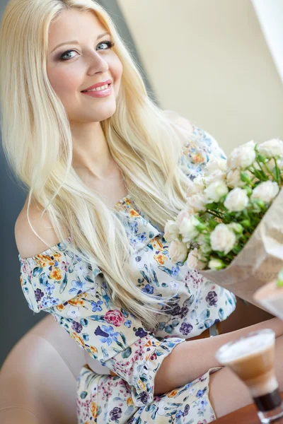 花と美しい金髪の笑みを浮かべて女性のポートレート — ストック写真