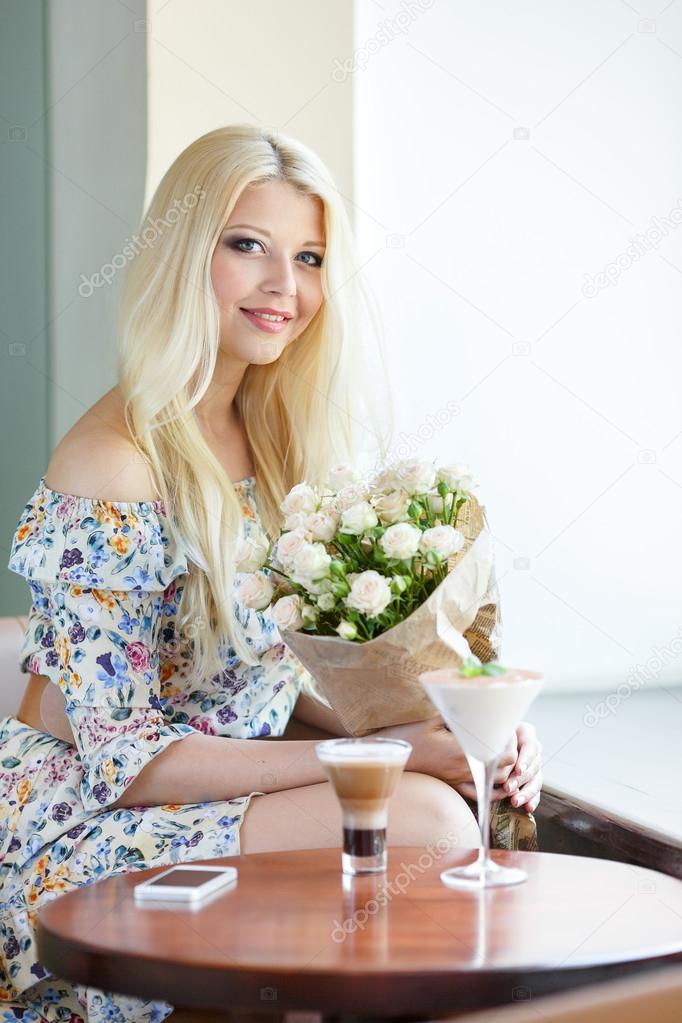 Portrait of beautiful blonde smiling woman with flowers