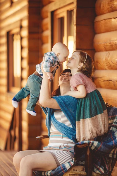 木造の家の近くに座って子供とママ — ストック写真