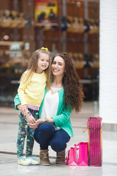 Uma jovem mãe e sua filha, fazendo compras — Fotografia de Stock