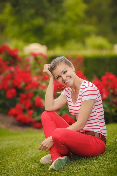 Park yaz yeşil çim üzerinde oturan kız. — Stok fotoğraf