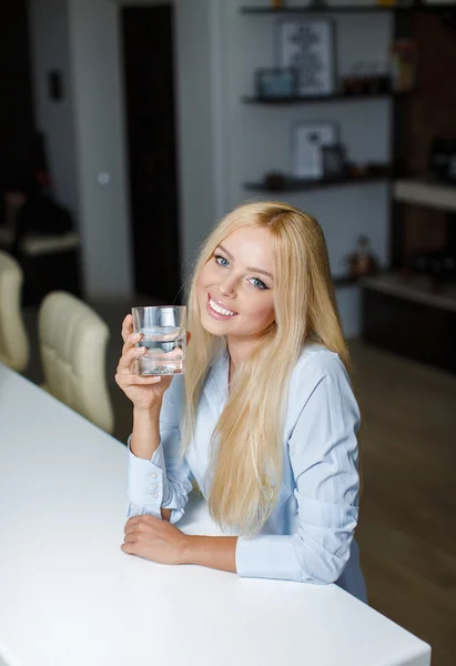 美しい若い女性は水でガラスを保持します。 — ストック写真