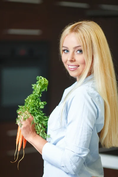 Vacker ung kvinna nära kylskåpet med hälsosam mat. — Stockfoto