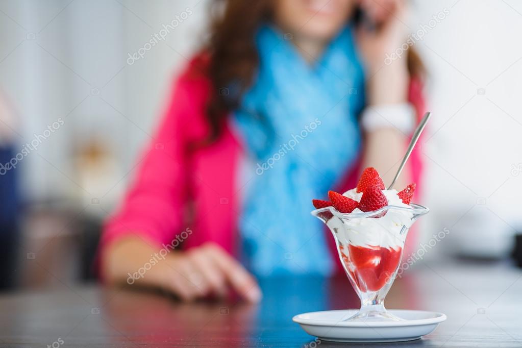 Young woman, dessert ice cream with strawberries