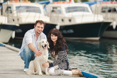 Limanda bir köpekle oynayan genç Çift