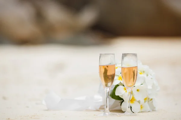 Wedding bouquet of frangipani and champagne glasses — Stock Photo, Image