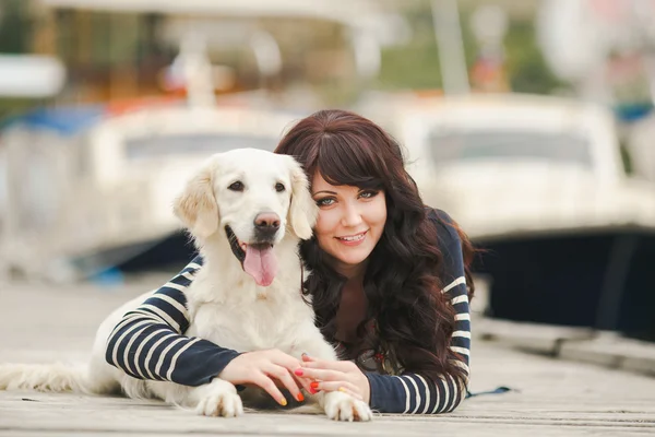 Bella ragazza con un cane sul molo in estate — Foto Stock