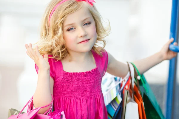 Leuke preschool meisje lopen met zakken. — Stockfoto