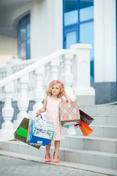 Divertida niña preescolar caminando con bolsas . — Foto de Stock