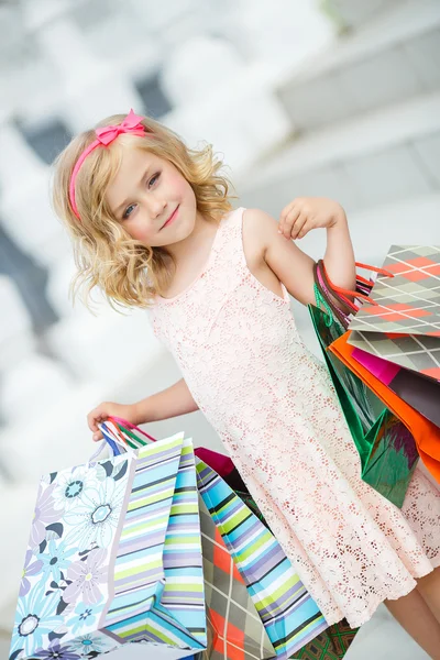 Kleine Mädchenmode mit Paketen im Einkaufszentrum. — Stockfoto