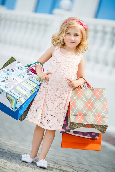 Μικρό κορίτσι μόδας με πακέτα στο εμπορικό κέντρο. — Φωτογραφία Αρχείου