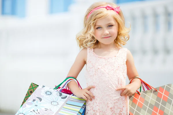 Weinig meisje mode met pakketten in het winkelcentrum. — Stockfoto
