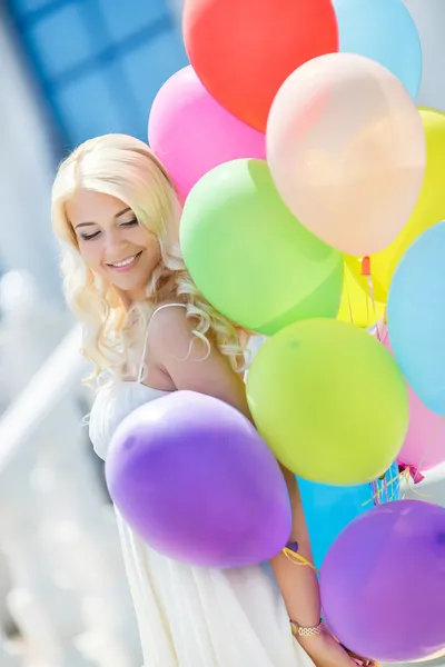 En ung kvinna med stora färgglada latex ballonger — Stockfoto