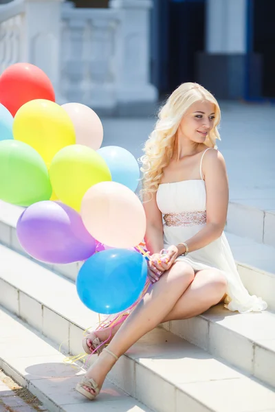 Una giovane donna con grandi palloncini di lattice colorati — Foto Stock