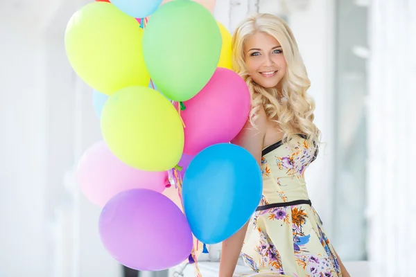 Een jonge vrouw met grote kleurrijke latex ballonnen — Stockfoto