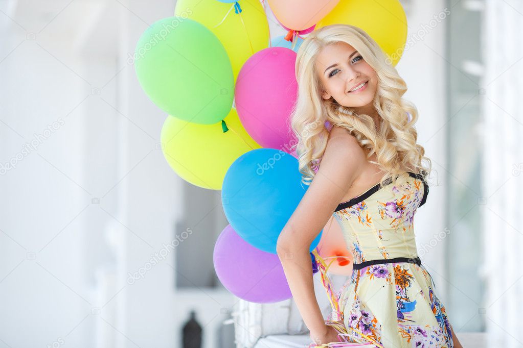 A young woman with large colourful latex balloons