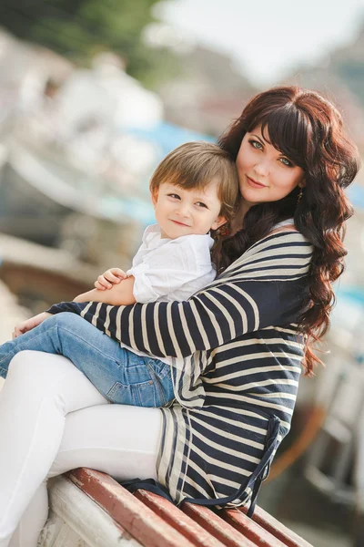 Happy mother and son sitting on the quay. — Stock Photo, Image