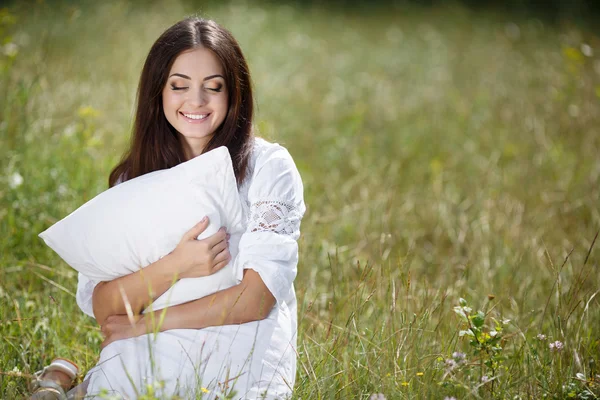 La chica con una almohada en la hierba fresca de primavera . —  Fotos de Stock