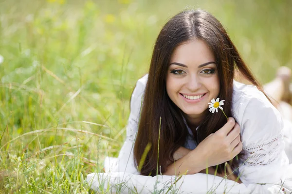 Das Mädchen mit dem Kopfkissen auf dem frischen Frühlingsgras. — Stockfoto