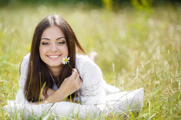 Девушка с подушкой на свежей весенней траве . — стоковое фото