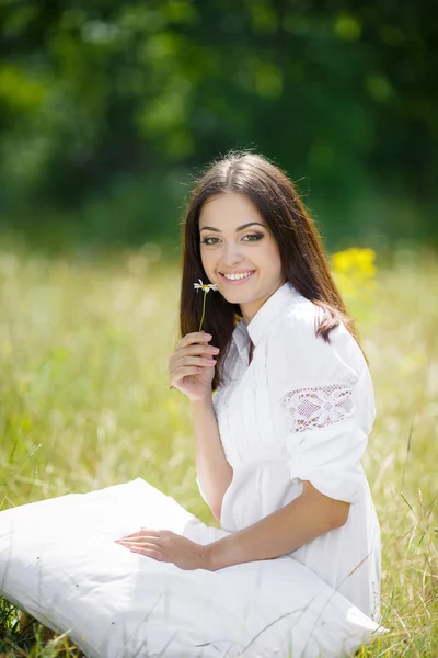 A menina com um travesseiro na grama fresca da primavera . — Fotografia de Stock
