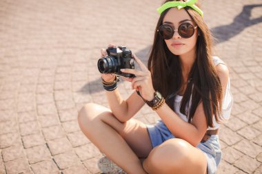 bir kız şehir sokaklarında eski fotoğraf makinesi fotoğraf çeker.