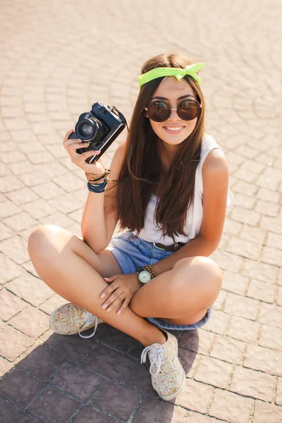 A girl takes pictures the old camera on city streets. — Stock Photo, Image