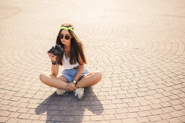 A girl takes pictures the old camera on city streets. — Stock Photo, Image