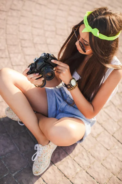 Una chica toma fotos de la vieja cámara en las calles de la ciudad . — Foto de Stock