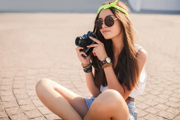 A girl takes pictures the old camera on city streets. — Stock Photo, Image