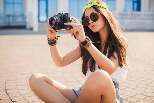 Девушка фотографирует старую камеру на улицах города . — стоковое фото