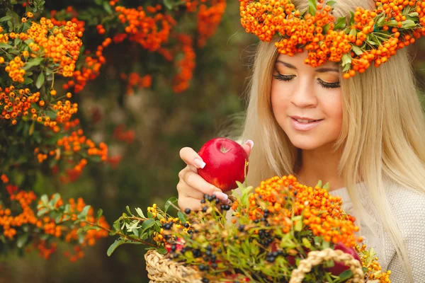 Flicka i orange krans med rött äpple i handen — Stockfoto