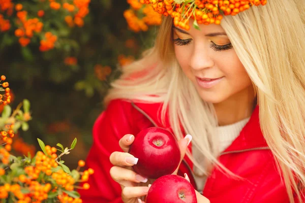 手で赤いリンゴとオレンジ色の花輪の女の子 — ストック写真
