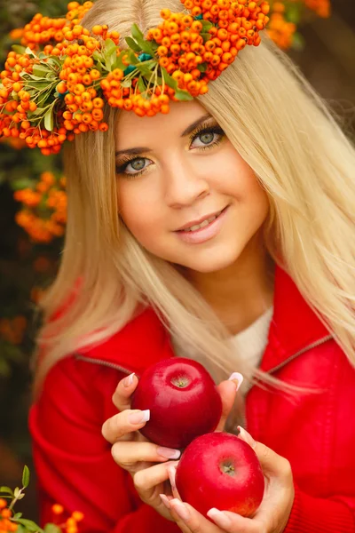 Flicka i orange krans med rött äpple i handen — Stockfoto