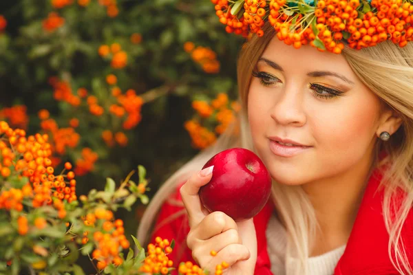 Dívka v oranžový věnec s červenými jablky v ruce — Stock fotografie