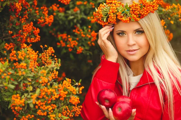 手で赤いリンゴとオレンジ色の花輪の女の子 — ストック写真