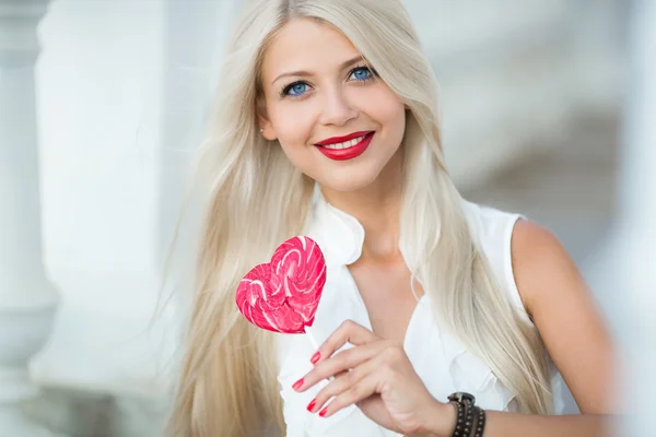 エレガントな金髪の女性は、心臓の形でロリポップ — ストック写真