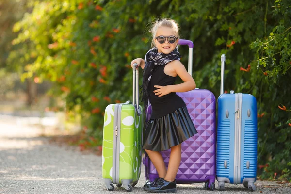 Smuk ung dame rejser med en kuffert - Stock-foto