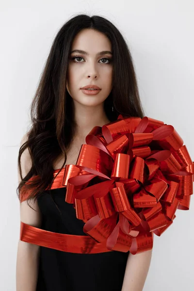 Young pretty woman wrapped with ribbon, red gift ribbon — Stock Photo, Image