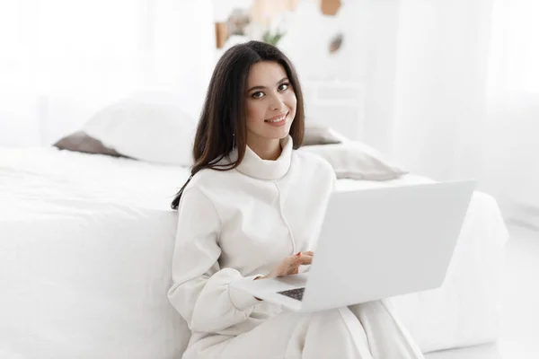 Mujer joven y acogedora que trabaja en el ordenador portátil en casa interior — Foto de Stock