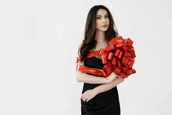 Giovane bella donna avvolta con nastro, nastro regalo rosso — Foto Stock