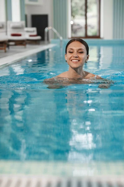 Yüzme havuzunda gülümseyen güzel bir kadın