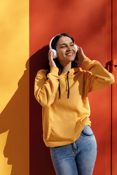 Joven mujer sonriente escuchar la música en los auriculares —  Fotos de Stock