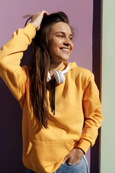 Giovane donna sorridente con cuffie all'aperto — Foto Stock